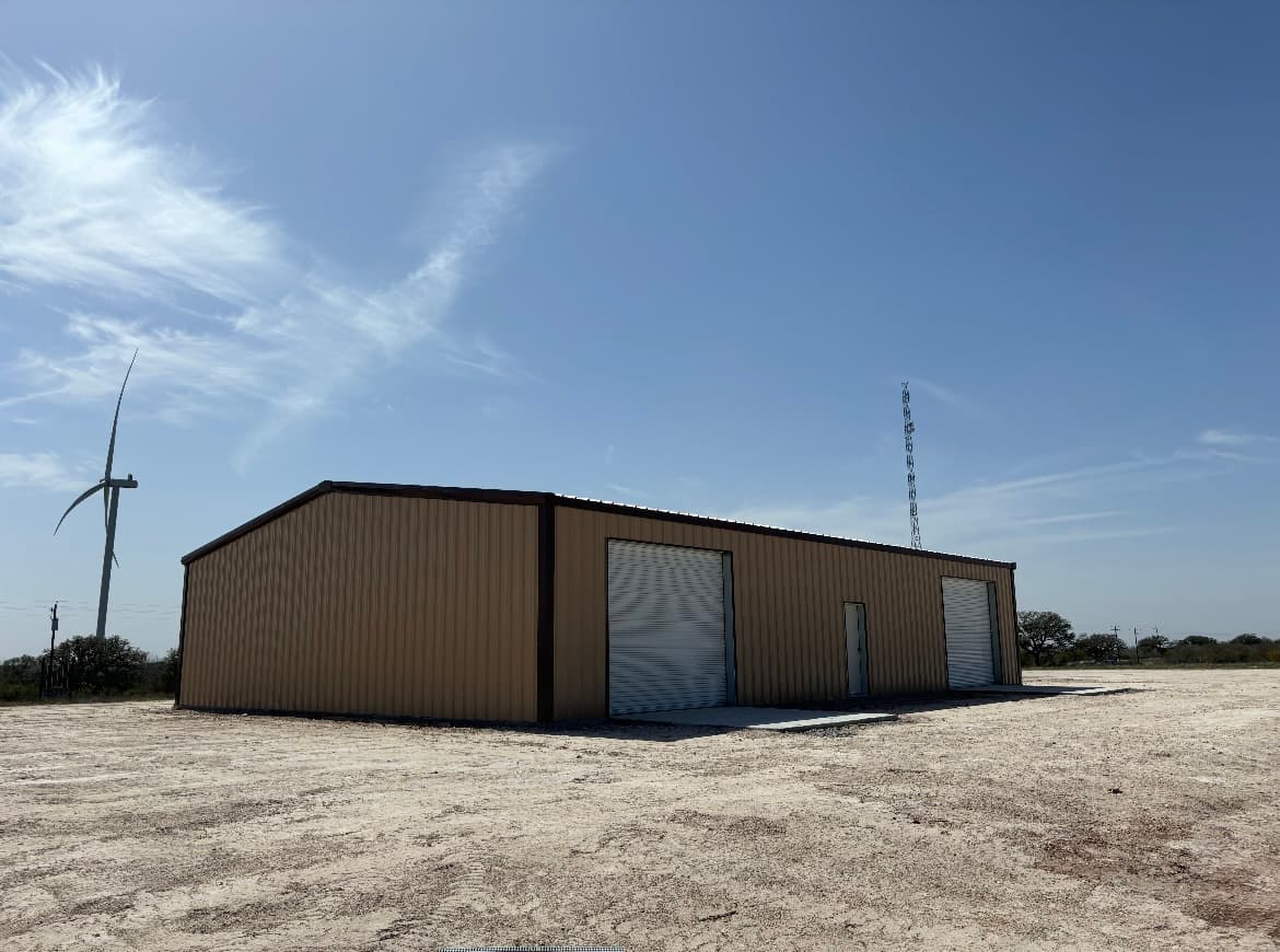 Tan industrial metal building with multiple roll-up doors, finished and ready for use, South Texas / Coastal Bend region